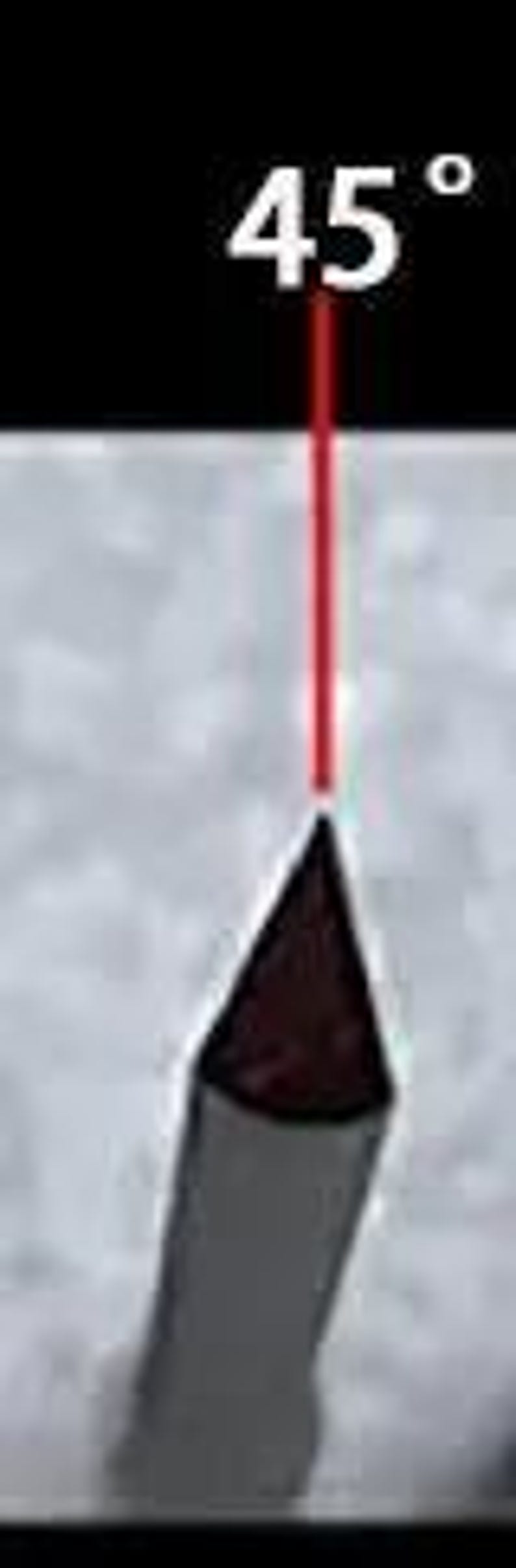 May include: A close-up of a red laser beam pointing at a 45-degree angle towards a silver metal object. The object is shaped like a triangle with a rounded tip.