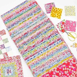 May include: A large stack of colourful fabric squares with floral patterns. The fabric is arranged in rows and is a mix of pink, blue, green, yellow, and white.