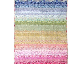 Op de afbeelding: Een kleurrijk gestreept dekbed met een regenboogpatroon. Het dekbed is gemaakt van verschillende bloemenstoffen in tinten roze, paars, blauw, groen, geel en oranje.