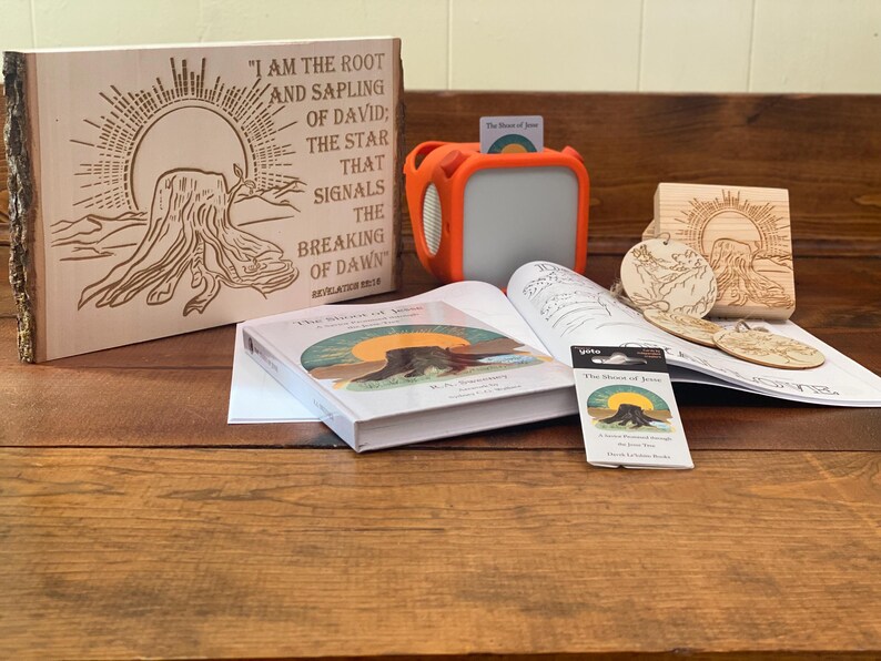 May include: Wooden plaque with etched text and a tree stump design, accompanied by a book, orange speaker, and wooden ornaments. The plaque reads "I AM THE ROOT AND SAPLING OF DAVID; THE STAR THAT SIGNALS THE BREAKING OF DAWN."