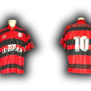 May include: Two vintage football shirts. One shirt is red and black striped with the word "LUBRAX" across the front. The other shirt is red and black striped with the number "10" on the back and the word "PETROBRA" across the top.