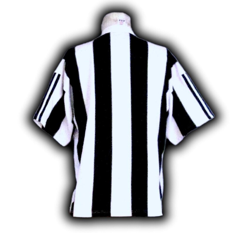 Op de afbeelding: Een zwart-wit gestreept shirt met korte mouwen. Het shirt heeft een witte kraag en verticale zwarte strepen over de voor- en achterkant. De mouwen hebben zwarte strepen op de schouders. Geschikt voor sport of casual wear.