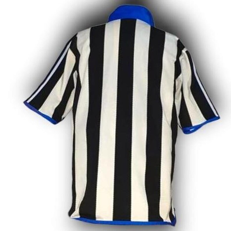 Op de afbeelding: Een gestreept scheidsrechtershirt in zwart en wit, met een blauwe kraag en mouwboorden. Het shirt heeft korte mouwen en is ontworpen voor sportofficials. De stof lijkt licht van gewicht.