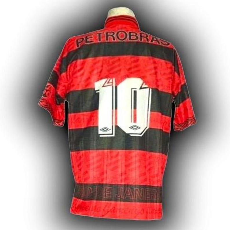May include: Red and black striped football shirt with the number 10 in white on the back. The shirt features the word "PETROBRAS" across the shoulders and "RIO DE JANEIRO" at the bottom.
