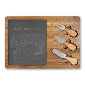 Op de afbeelding: Houten kaasplank met een leistenen inzet met de tekst "Lake Tahoe, CA" en een kaart. Inclusief drie kaasmesjes met houten handvatten en roestvrijstalen messen. Coördinaten zijn ook inbegrepen.