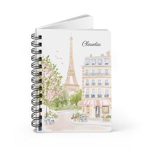 Angled view of personalized Paris travel notebook with floral pastel artwork