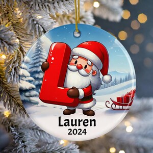Adorno navideño personalizado con nombre de niño 2024, Papá Noel sosteniendo la letra L, acabado mate, regalo navideño personalizable para niños y nietos