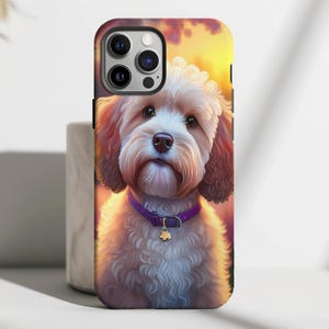 May include: A phone case with a cute, fluffy, light brown dog with a purple collar and a gold charm. The dog is looking at the camera and has a soft, gentle expression. The background is a blurred image of a sunset.