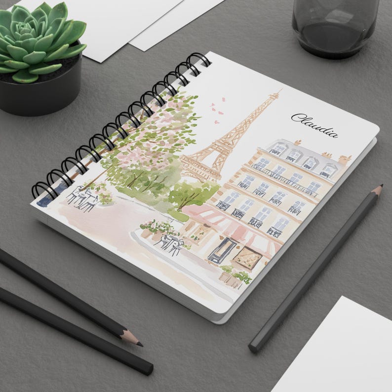 Front cover of Paris France notebook showing Eiffel Tower and pastel buildings with custom name