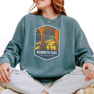 Unisex Mammoth Cave National Park sweatshirt featuring a relaxed fit, ribbed cuffs, and OEKO-TEX certified dyes. Made from durable, soft fabric with a fleece interior. Colors: Pepper, Terracotta, Butter, White, Blue Spruce, Blue Jean, and True Navy.