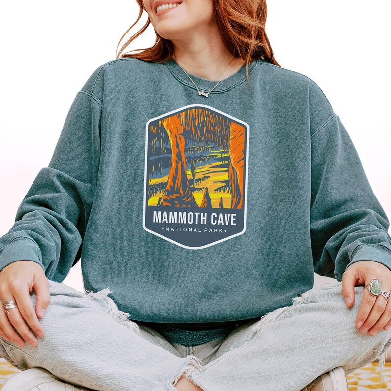 Unisex Mammoth Cave National Park sweatshirt featuring a relaxed fit, ribbed cuffs, and OEKO-TEX certified dyes. Made from durable, soft fabric with a fleece interior. Colors: Pepper, Terracotta, Butter, White, Blue Spruce, Blue Jean, and True Navy.