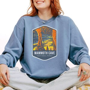 Unisex Mammoth Cave National Park sweatshirt featuring a relaxed fit, ribbed cuffs, and OEKO-TEX certified dyes. Made from durable, soft fabric with a fleece interior. Colors: Pepper, Terracotta, Butter, White, Blue Spruce, Blue Jean, and True Navy.