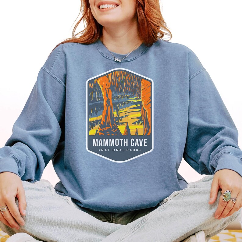 Unisex Mammoth Cave National Park sweatshirt featuring a relaxed fit, ribbed cuffs, and OEKO-TEX certified dyes. Made from durable, soft fabric with a fleece interior. Colors: Pepper, Terracotta, Butter, White, Blue Spruce, Blue Jean, and True Navy.