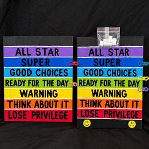 May include: Two rectangular signs featuring horizontal rainbow stripes with black text reading ALL STAR, SUPER, GOOD CHOICES, READY FOR THE DAY, WARNING, THINK ABOUT IT, and LOSE PRIVILEGE. The right sign includes a small bag of white plastic clips.