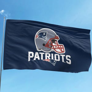 May include: A blue flag with the New England Patriots logo. The logo is a white helmet with a red stripe and the word "PATRIOTS" in white letters.