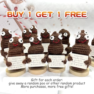 May include: A collection of brown crocheted poop figures with white eyes and red smiles, each holding a sign with the text "Positive Poo." The signs read "I may be a tiny poo, but I believe in you. Go do your sh*t." The image includes the text "BUY 1 GET 1 FREE."
