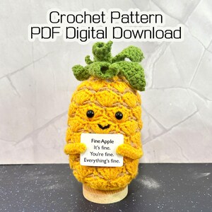 Puede incluir: Un juguete de peluche de piña tejido a ganchillo en amarillo y verde con ojos de cuentas negras y una pequeña sonrisa. Sostiene un letrero cuadrado blanco que dice: Fine Apple, It's fine, You're fine, Everything's fine. Crochet Pattern PDF Digital Download.