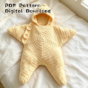 Può includere: Una coperta indossabile all'uncinetto color giallo pallido a forma di stella con cappuccio e due bottoni abbinati sul lato. Il testo PDF Pattern Digital Download è visibile in alto. Il capo presenta un motivo a punti strutturato su tutto il design.