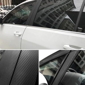 Puede incluir: Un coche blanco con molduras de fibra de carbono negra en el marco de la puerta y los pilares de las ventanas. La fibra de carbono tiene un patr&oacute;n tejido. Las ventanas reflejan un edificio.
