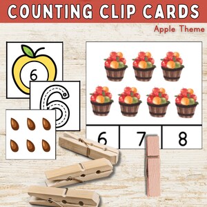 May include: Counting clip cards with an apple theme.  The cards feature baskets of apples, a single apple with a number 6 inside, a number 6 with a dotted line for tracing, and a set of 6 brown seeds.  The numbers 6, 7, and 8 are printed on the bottom of the cards.  There are three wooden clothespins.