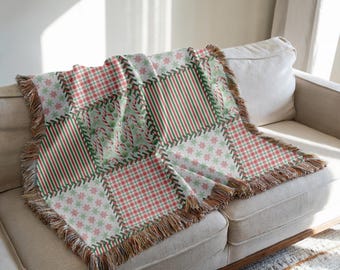 Könnte beinhalten: Eine Patchwork-Wurfdecke mit Weihnachtsmotiv, mit Quadraten aus rot-grünen Streifen, Karomustern und Zuckerstangenmustern. Die Decke hat einen Fransenrand und ist über ein beiges Sofa drapiert.