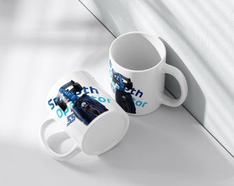May include: Two white ceramic mugs with a blue and black race car design. The mugs have the text "Smooth Operator" and the number "55" printed on them. The mugs are on a white surface.