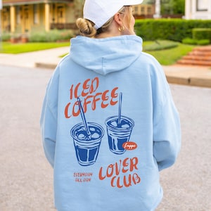 May include: Light blue hoodie with the words "ICED COFFEE LOVER CLUB" in orange and two coffee cup illustrations. The hoodie also has the text "EVERYDAY ALL DAY" in white.