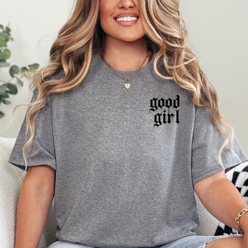 a woman sitting on a couch wearing a grey shirt