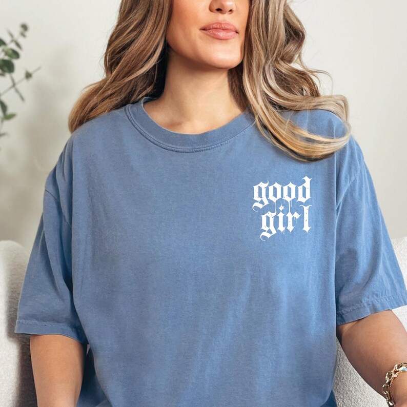 a woman sitting on a couch wearing a blue shirt