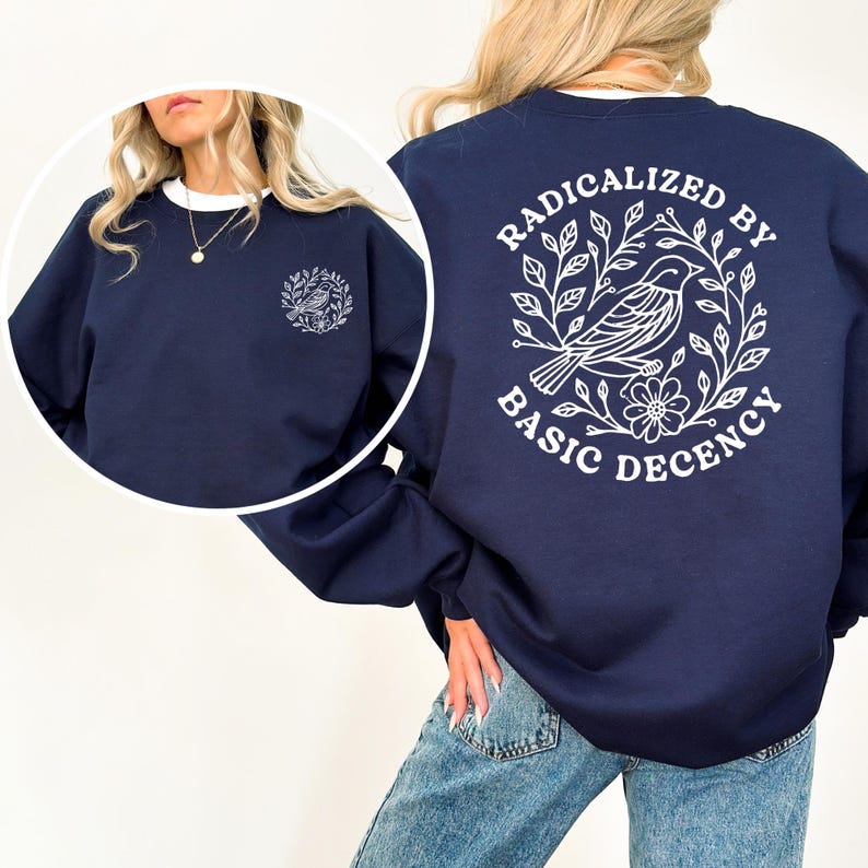 A woman wearing a navy blue sweatshirt with a white graphic design on the back.