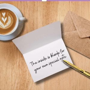 Mockup of a folded card showing a blank white interior for personalized messages, styled on a clean desk with a coffee cup and gold pen.