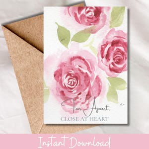 May include: A watercolor greeting card featuring pink roses with green leaves, accompanied by a brown envelope. The card reads "Far Apart, Close at Heart" in elegant script. The overall design is soft and romantic.