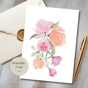 Könnte beinhalten: Eine weiße Grußkarte mit einer Aquarellillustration von rosa, pfirsichfarbenen und hellvioletten Blumen mit grünen Blättern. Ein kreisförmiges Etikett mit dem Text Printable Card befindet sich links neben einem goldenen Stift und einem Umschlag.