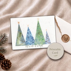 Pu&ograve; includere: Un biglietto d'auguri rettangolare con un'illustrazione ad acquerello di quattro alberi di Natale stilizzati nei toni del verde e del blu, ciascuno sormontato da una stella dorata. Il testo "All is calm, all is bright" &egrave; stampato in nero.