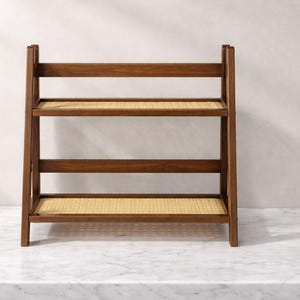 May include: A three-tiered wooden shelf with woven rattan shelves. The frame is a dark brown color, and the shelves are a light tan. The shelf is designed to stand on the floor and is suitable for storage or display.