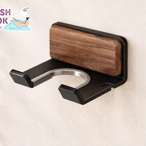 Peut inclure: Un support de rasoir mural noir et boisé. Le support a un dessus rectangulaire en bois et une pièce métallique incurvée pour tenir le rasoir. Le texte "FRESH LOOK BY NATHAN" est dans le coin supérieur gauche.