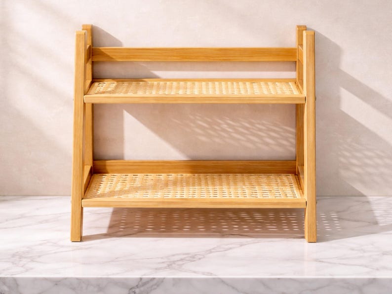 May include: A two-tiered, light-brown wooden shelf with woven rattan shelves. The shelf has a rectangular frame and is designed for storage or display. The natural wood grain and woven texture create a warm, inviting aesthetic.