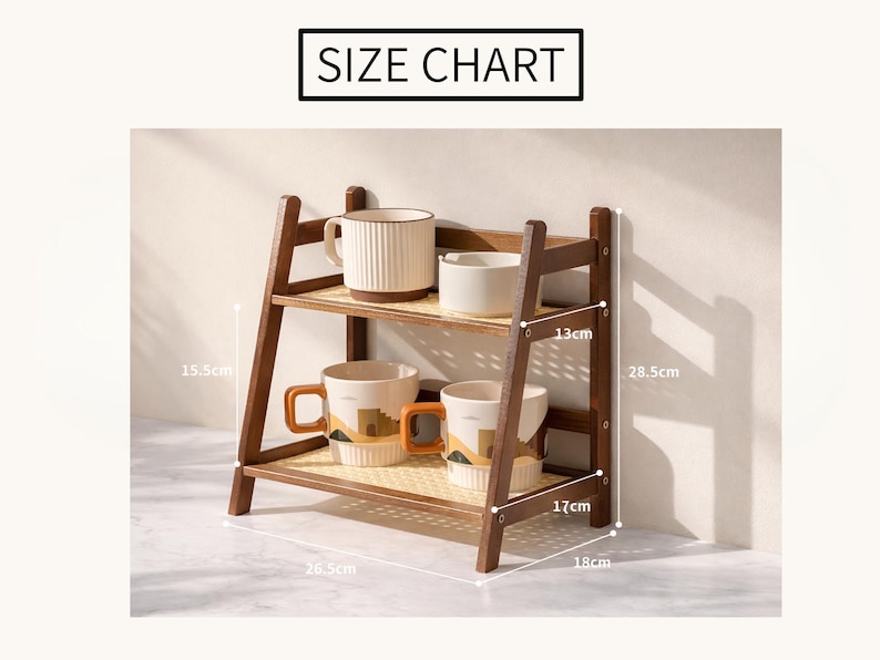 May include: A two-tiered wooden shelf with a woven base, holding cream-colored mugs and bowls. The shelf is 18 inches wide, 17 inches deep, and 28.5 cm tall. The top shelf is 13 cm from the top. The text "SIZE CHART" is at the top.