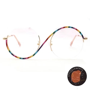 May include: Round eyeglasses with a gold frame and rainbow-striped detailing. The lenses are clear, and the frame has a unique, continuous design. The glasses have a modern, stylish appearance.