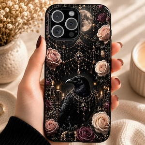 May include: Black phone case featuring a detailed illustration of a raven adorned with jewelry, surrounded by roses, candles, and a full moon. The design has a gothic aesthetic with a dark, elegant theme.