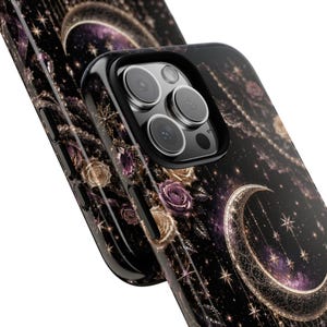 May include: Black phone case with a celestial design featuring a crescent moon, stars, and roses. The case has a glossy finish and a black border. The design incorporates shades of purple, gold, and white.