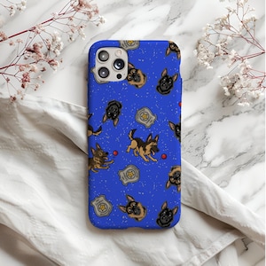 Puede incluir: Funda de teléfono azul con un patrón repetido de pastores alemanes de dibujos animados, pelotas rojas y placas de policía. La funda tiene un acabado brillante y un recorte para la cámara.
