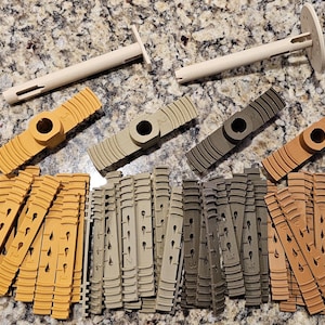 May include: A set of 30 plastic pieces in three colors: brown, tan, and gray. The pieces are in various shapes, including long strips, small squares, and larger pieces with holes in the center.