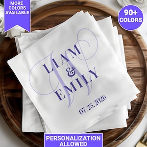 May include: White napkins with the names "Liam & Emily" and the date "07.25.2026" printed in purple. The napkins are stacked on a wooden tray. Text on the image says "More Colors Available", "90+ Colors", and "Personalization Allowed".
