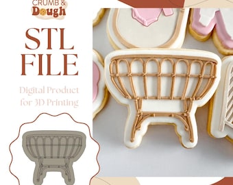 May include: An image of a cookie shaped like a baby cradle, with a light brown rattan design. The cookie is decorated with white icing and light brown details. The image also includes the text "STL FILE" and "Digital Product for 3D Printing".