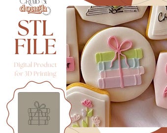 May include: Image of decorated cookies, some with a book theme. One round cookie has a stack of books tied with a pink bow. The image includes the text "STL FILE" and "Digital Product for 3D Printing".