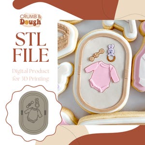 Puede incluir: Diseño de galleta con temática de bebé con un body rosa, un sonajero y un mordedor con forma de conejito. La imagen incluye el texto "STL FILE" y "Digital Product for 3D Printing" con un logo "CRUMB & Dough".