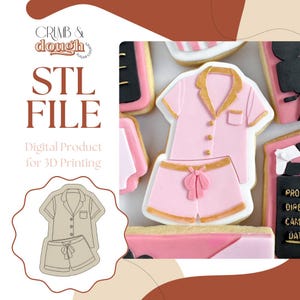 May include: Pink pajama-shaped cookie with gold trim and a bow detail. The cookie is part of a set of decorated cookies. The image also includes the text "STL FILE" and "Digital Product for 3D Printing".