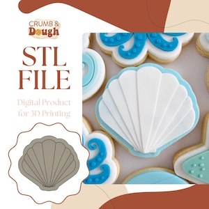 Puede incluir: Un archivo STL digital para la impresión 3D de un cortador de galletas con forma de concha. La imagen muestra un contorno gris del cortador y una galleta con forma de concha blanca decorada con glaseado azul.