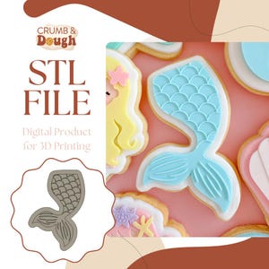 May include: A digital STL file for 3D printing a mermaid tail cookie cutter. The image shows a sample cookie decorated with blue and white icing, resembling a mermaid tail.